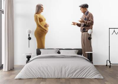 Pregnant woman in a yellow dress listening to an elderly man Wall mural