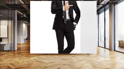 Professional man in a suit and tie leaning on a wall and pointing to the side Wall mural