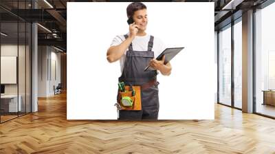 Repairman in a uniform holding a clipboard and talking on a mobile phone Wall mural