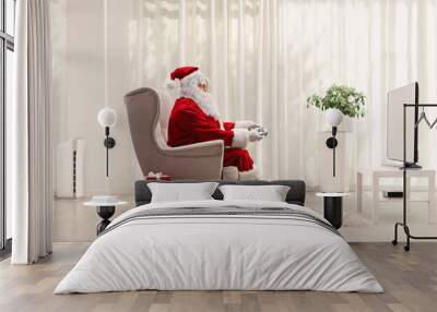 Santa claus with a joystick playing video games Wall mural