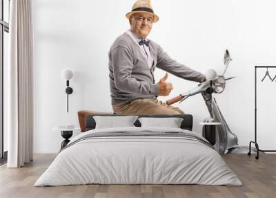 Senior man sitting on a vintage scooter and showing thumbs up Wall mural