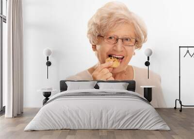 Senior woman eating a cookie Wall mural