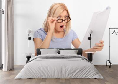 Shocked woman looking at the bills in disbelief Wall mural