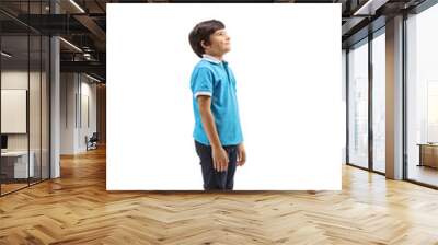 Smiling boy standing and looking upwards Wall mural