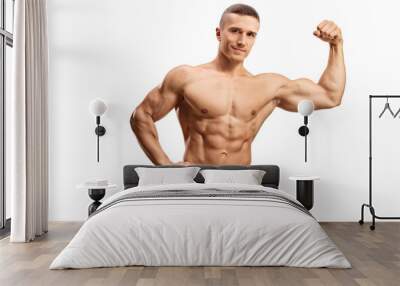 Strong muscular guy flexing bicep muscle topless and looking at camera Wall mural