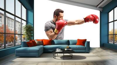 Strong young man punching with boxing gloves Wall mural