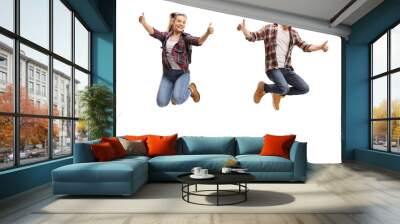 Teen boy and girl jumping and showing thumbs up Wall mural