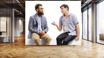 Two young men sitting on a banner and talking Wall mural