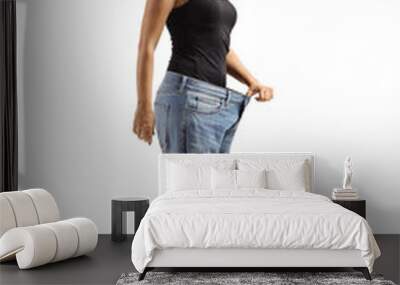 Woman wearing a big size jeans and weighing on a medical scale Wall mural