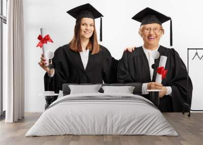 Young and senior female graduates holding diplomas Wall mural