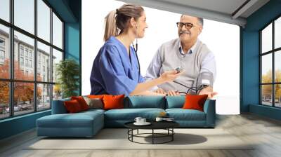 Young female urse checking blood pressure to an elderly man Wall mural