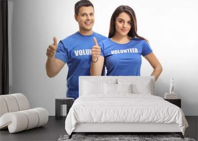 Young male and female volunteers smiling and showing thumbs up Wall mural