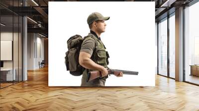 Young male hunter walking and holding a shotgun Wall mural