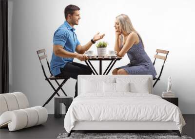 young man and a young woman sitting at a coffee table and talking Wall mural