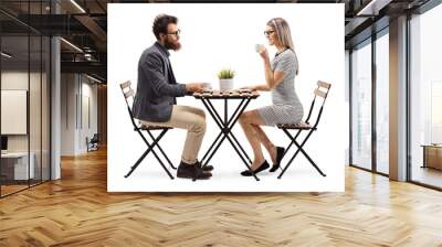 Young man and woman drinking coffee at a table Wall mural