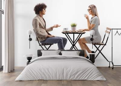 Young man and woman having coffee and talking Wall mural