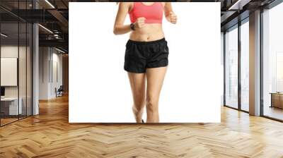 Young smiling woman in sportswear jogging towards camera Wall mural