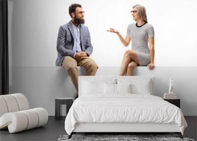 Young woman having a conversation with a bearded man while sitting on a panel Wall mural