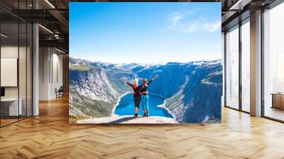 Happy people relax in cliff during trip Norway. Trolltunga hiking route Wall mural