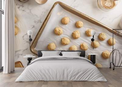 baking sheet with raw cookie dough balls, parchment paper, measuring cups, whisk, warm natural light, marble countertop, organized and inviting baking scene Wall mural