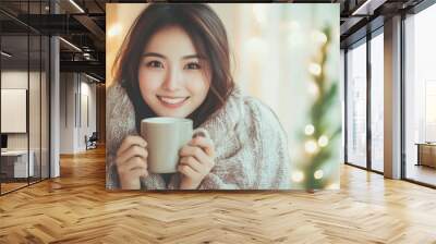 Asian woman in winter drinking coffee covered with blanket at home Wall mural