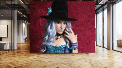 Woman Dressed as Blue Witch on Red Background Wall mural