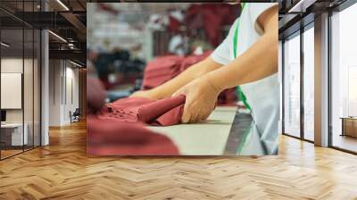 Employee's hands working in clothing factory Wall mural