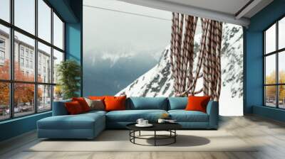 Rope on a background of snow-capped mountains and moody sky Wall mural