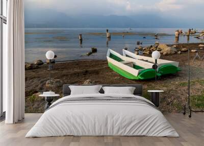 Two local fishermen canoes at the shore along lake Atitlan during sunset in San Pedro la Laguna, Guatemala Wall mural