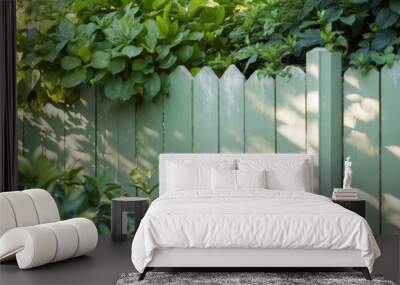 A serene green wooden fence framed by lush leaves in a tranquil garden setting. Wall mural