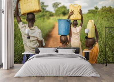 Group of young African kids walking with buckets and jerrycans on their head as they prepare to bring clean water back to their village. Wall mural