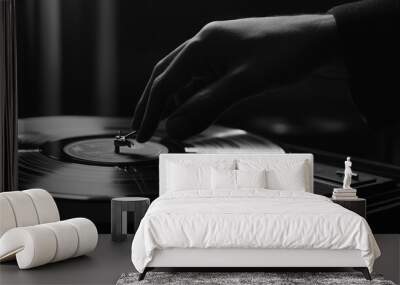 A hand gently places the needle on a vinyl record on a turntable. Wall mural