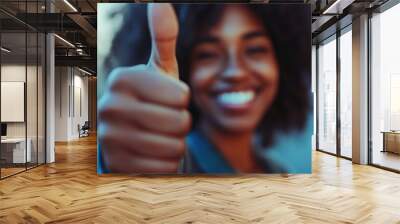 A smiling young woman gives a thumbs up, with a blurred city background. Wall mural