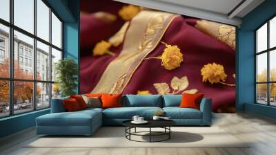 Closeup of a maroon silk saree with a golden border and yellow flowers. Wall mural