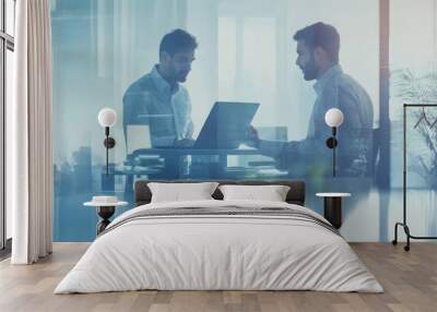 Two businessmen in a modern office, collaborating on a laptop, discussing ideas and projects. Wall mural