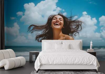 Laughing woman enjoying a day at the beach with a bright sky Wall mural