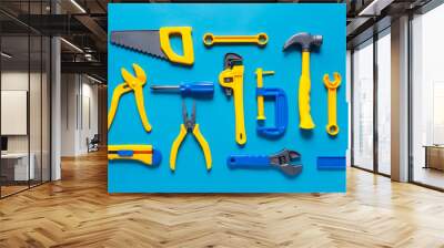 Toys background. Top view of toy tools on blue background Wall mural