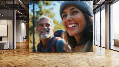 Middle aged caucasian couple hiking in the woods smiling at camera with toothy smile Wall mural