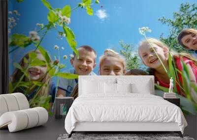 Group of children in the meadow on a background of blue sky Wall mural