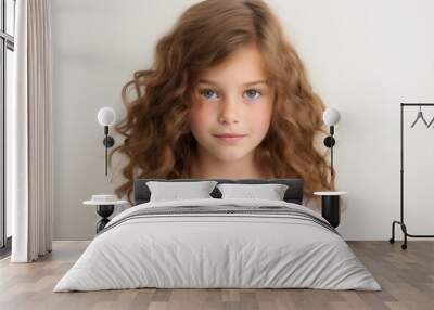 Portrait of a cute little girl with long curly hair on a gray background Wall mural