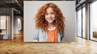 Portrait of a cute little girl with red curly hair over grey background Wall mural