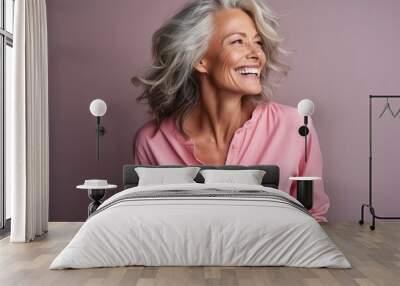 Portrait of a happy senior woman laughing and looking up against purple background Wall mural