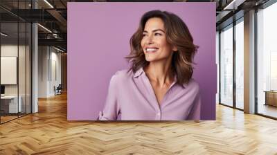 Portrait of happy smiling business woman in pink shirt, over purple background Wall mural