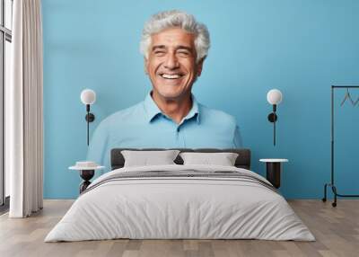 Portrait of smiling senior man with grey hair and blue shirt on blue background Wall mural