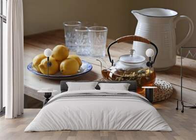 A rustic kitchen table with homemade herbal tea and fresh lemons Wall mural