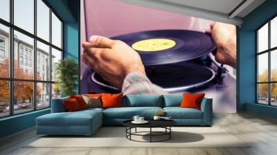 Hands placing record on turntable Wall mural