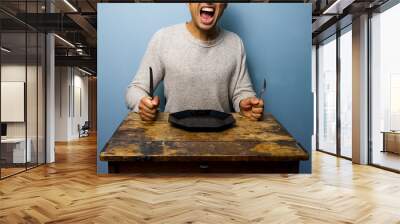 hungry young man is screaming for his dinner Wall mural