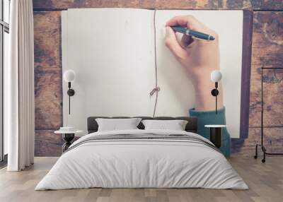 Male hand writing in notepad Wall mural