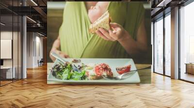 Mother with baby eating bacon sandwich Wall mural