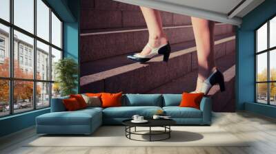 Young woman walking up stairs Wall mural